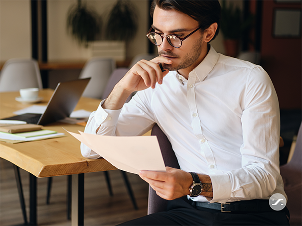 man-sitting-at-desk-reading-mail