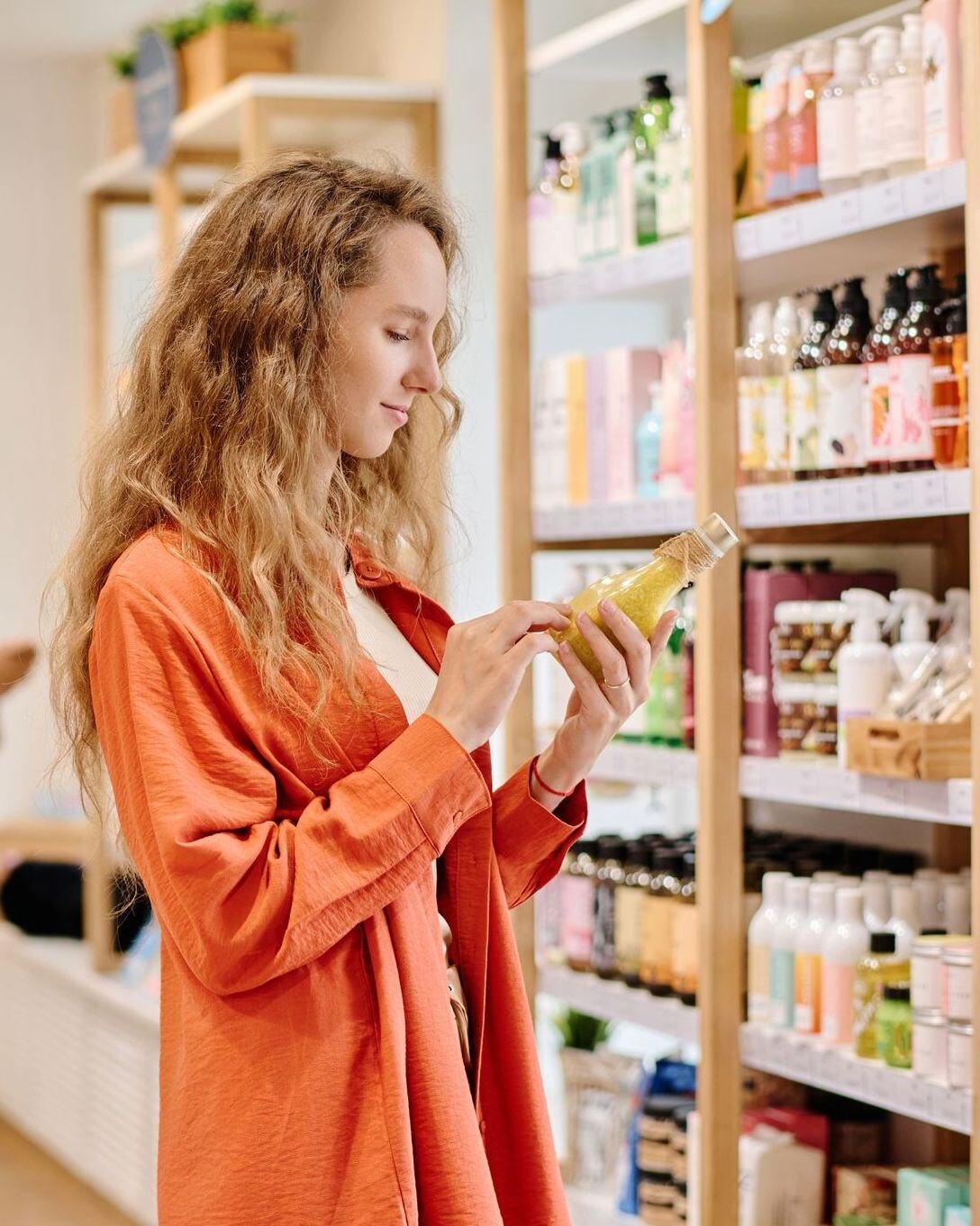 Woman shopping for soaps, looking at ingredient label. 